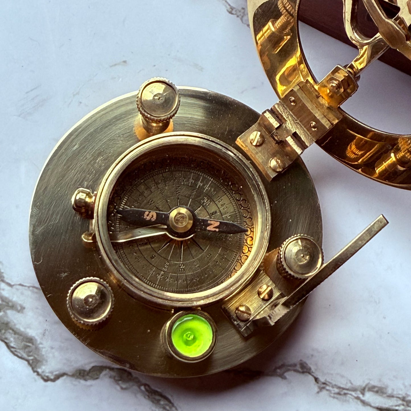 Brass compass on a marble surface