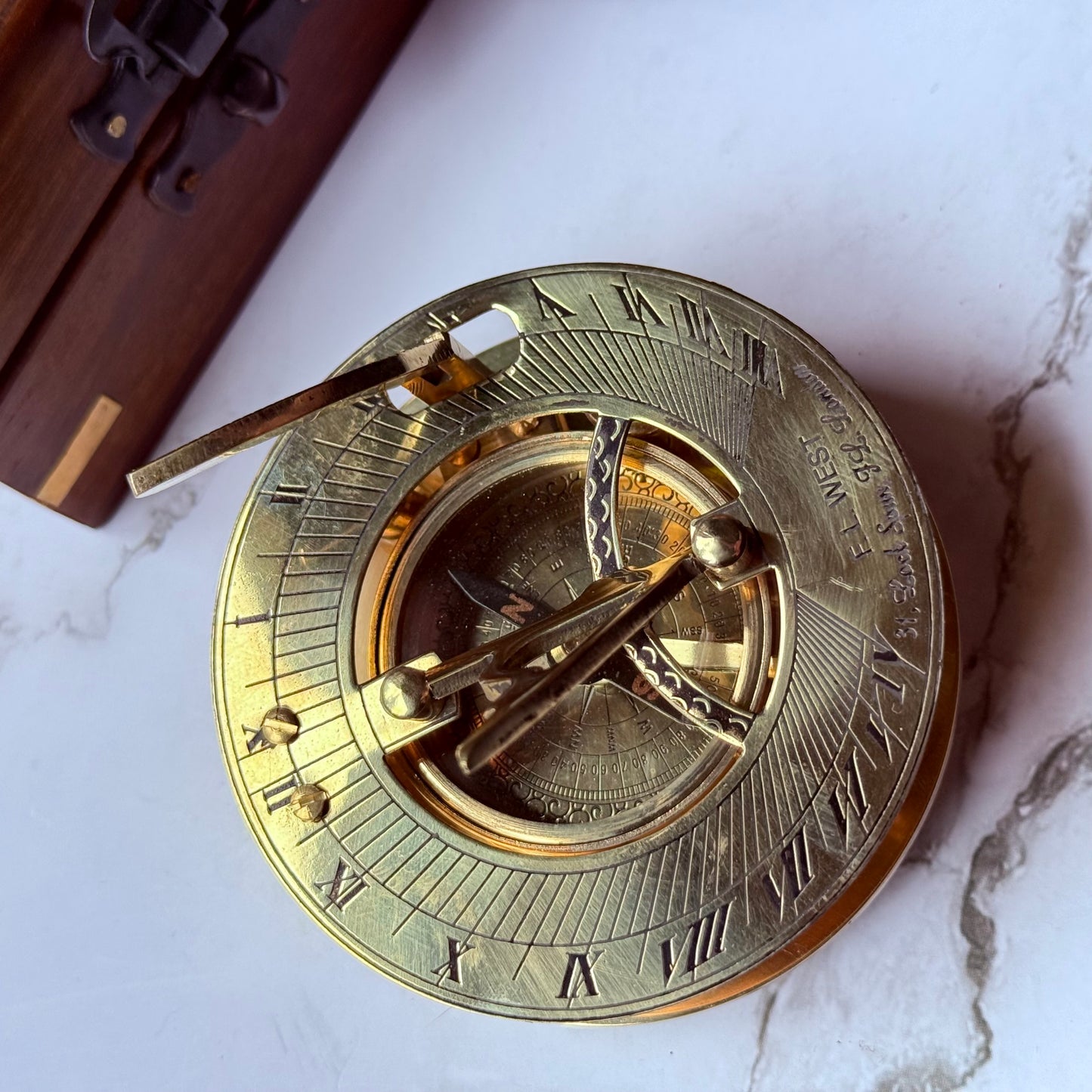 Brass sundial on a marble surface