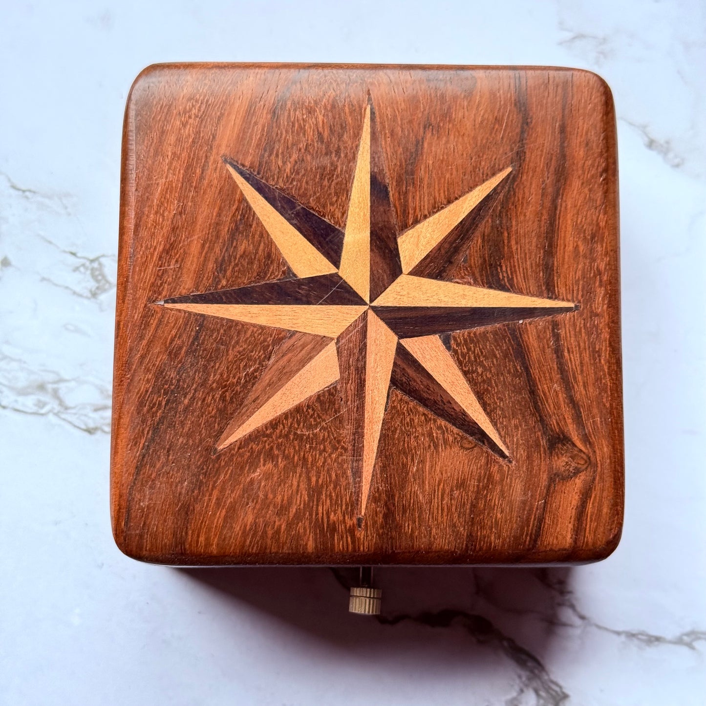 Wooden box with a star design on a marble surface