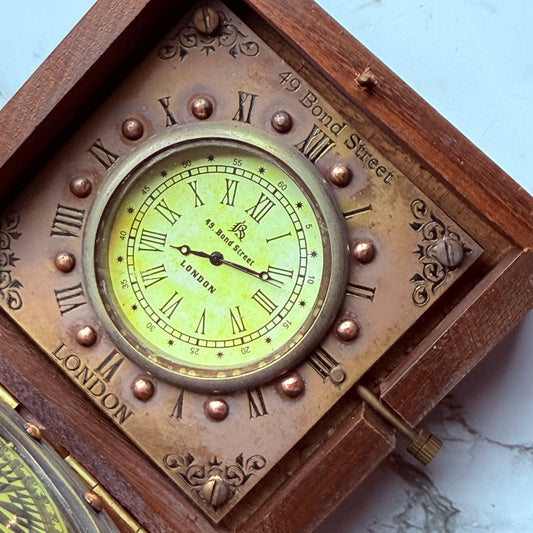 Vintage-style clock with Roman numerals and wooden frame on a marble surface