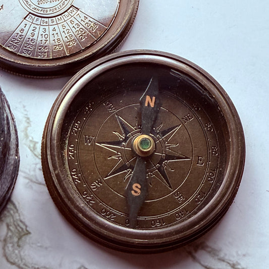 Close-up of a bronze compass on a marble surface