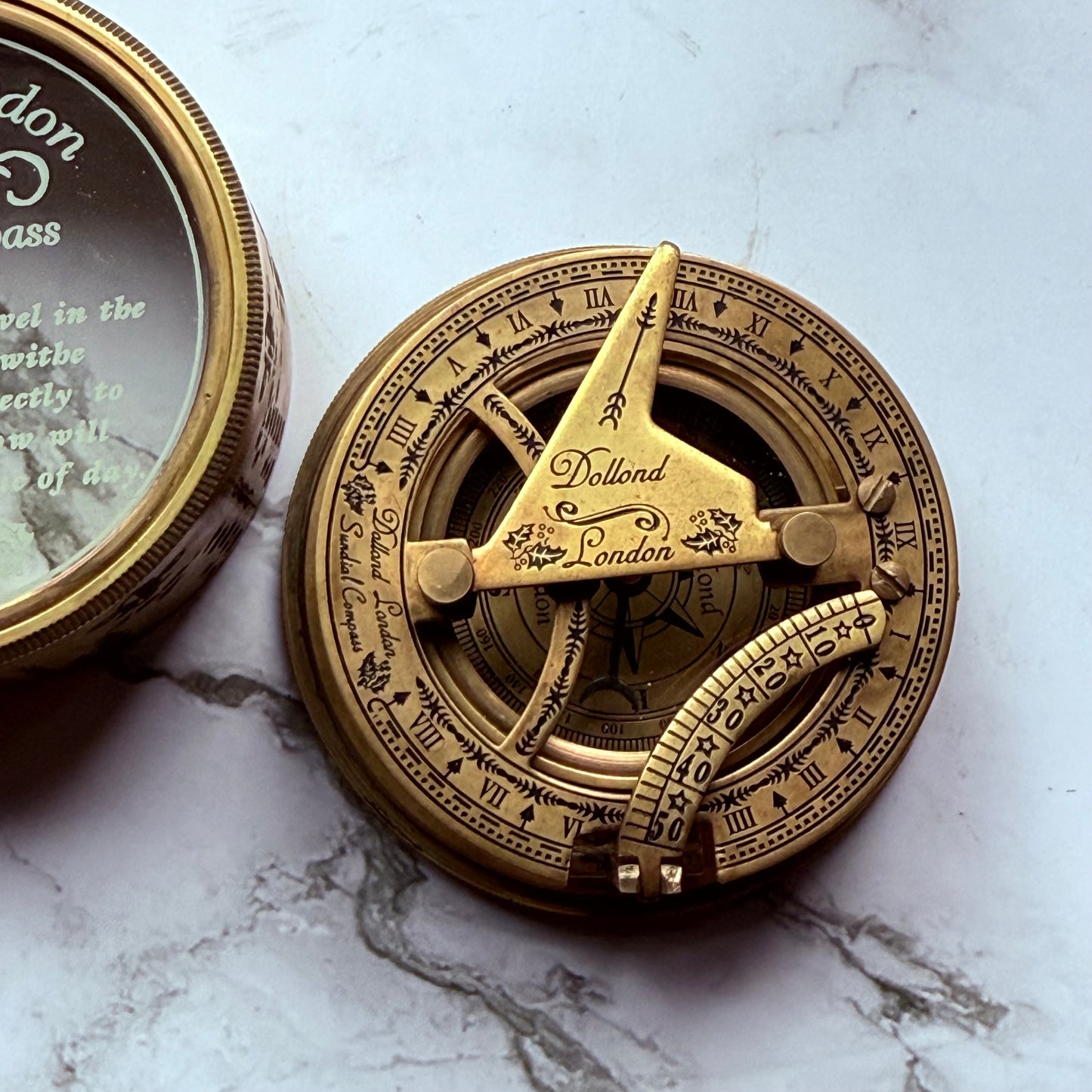 Brass sundial compass on a marble surface