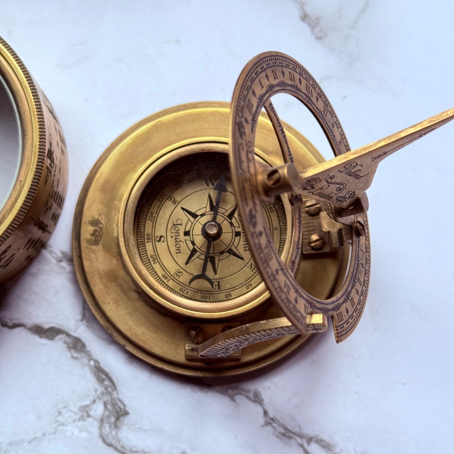 Brass compass on a marble surface