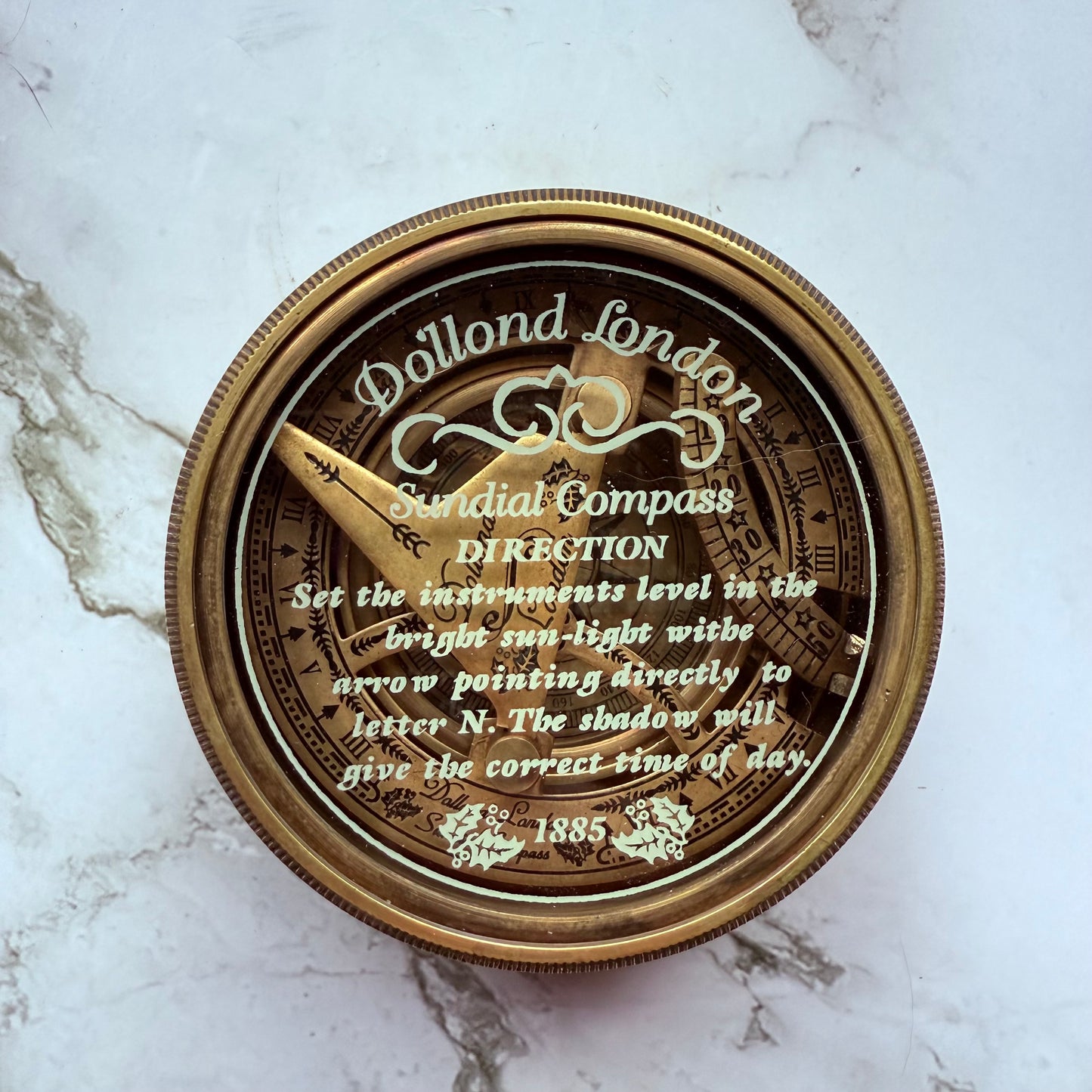 Dollond London sundial compass on a marble surface
