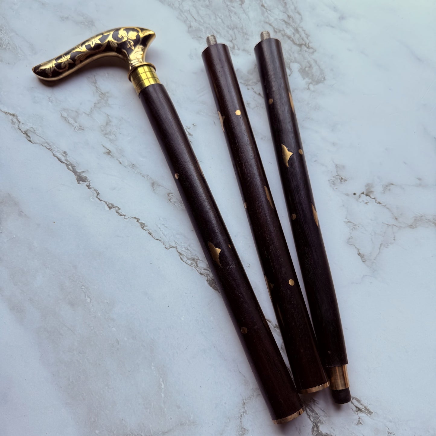 Decorative walking cane handle with brass floral pattern broken down into 3 parts