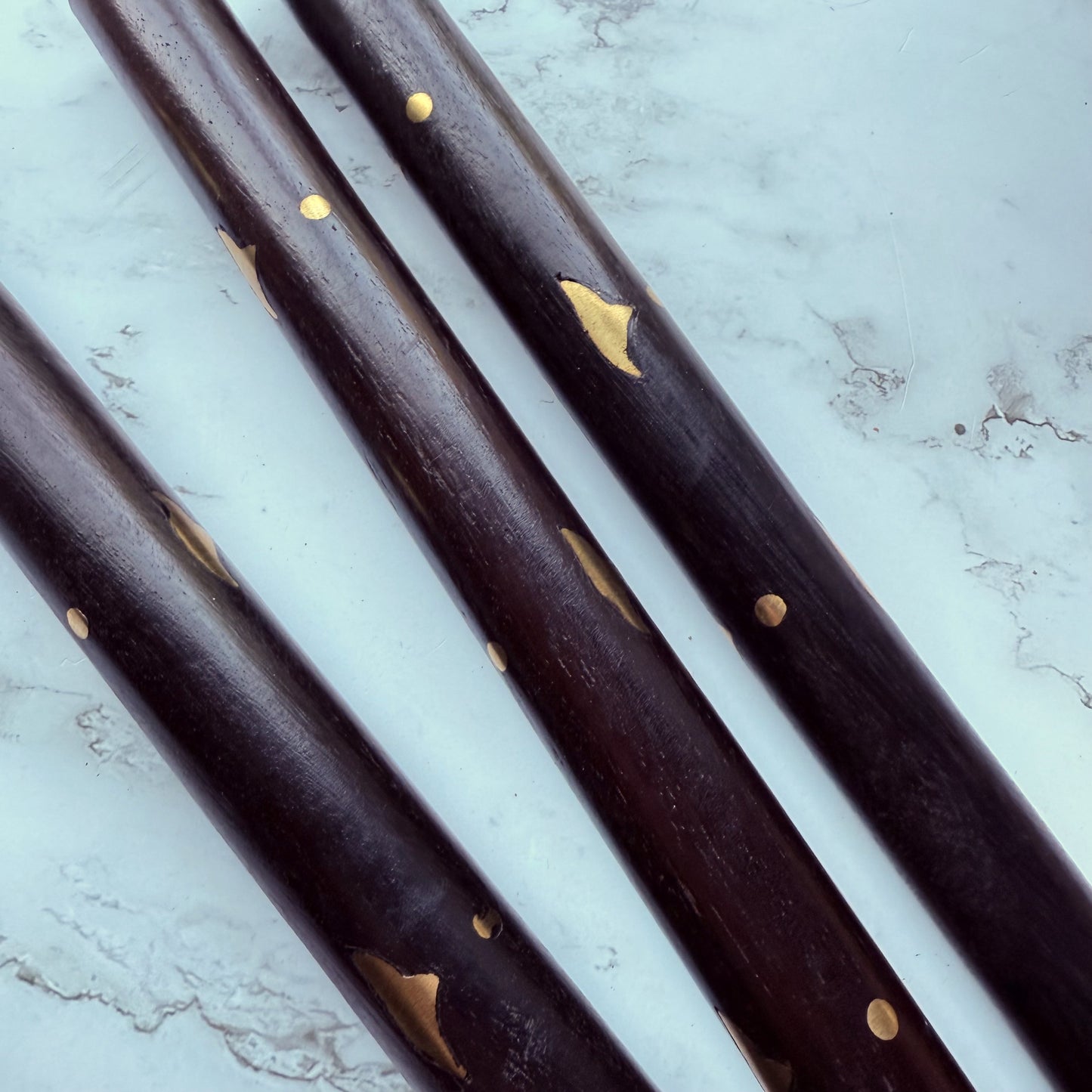 Close up of the wooden shaft of the cane with brass inlay design