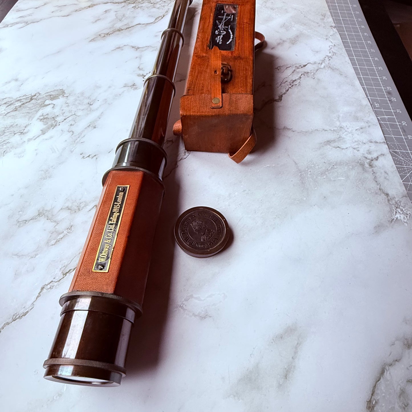 Vintage spyglass with leather case on a marble surface