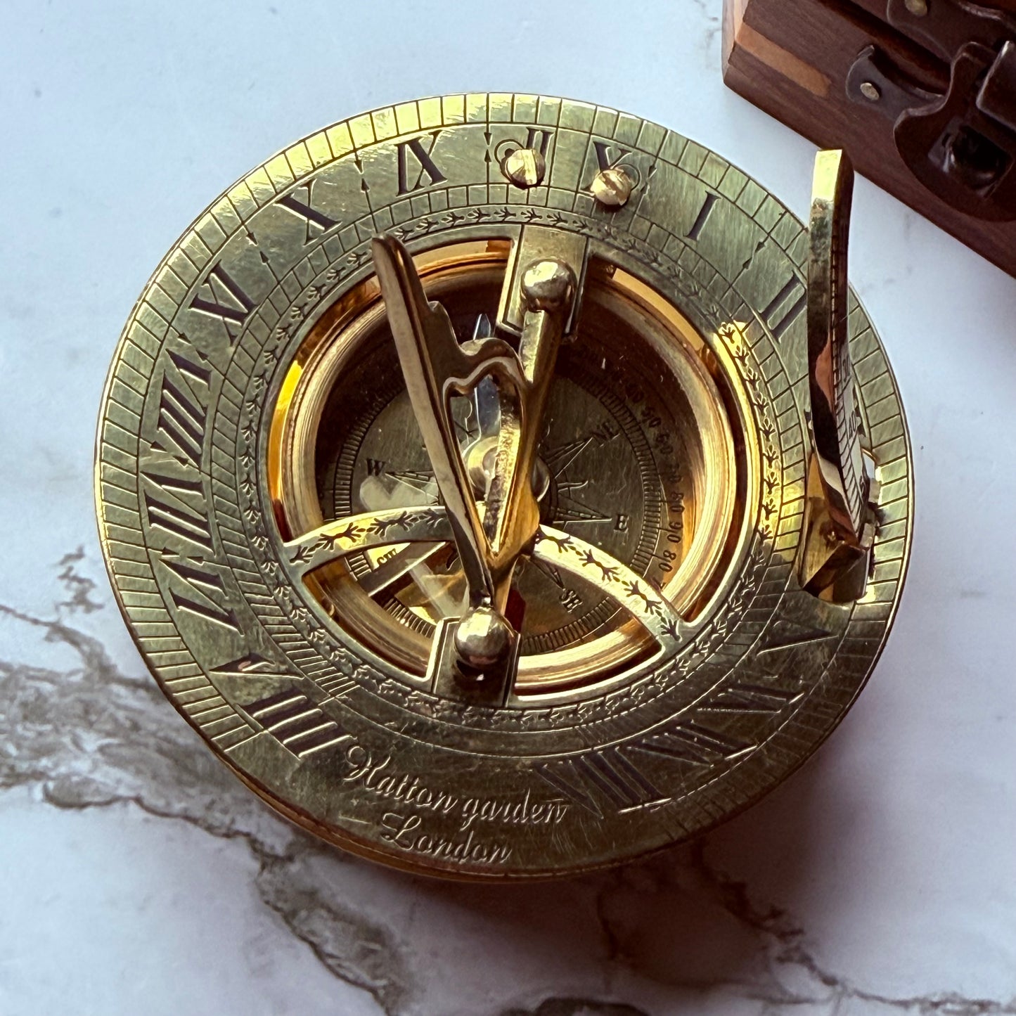 Brass sundial compass on a marble surface