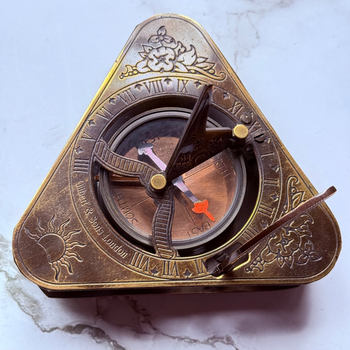 Brass compass sundial on a marble surface