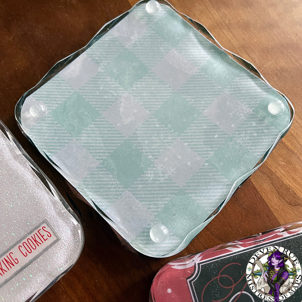 A close up of a coaster with mint plaid and snowflake illustrations.