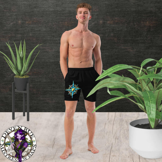 A model wears black swim trunks with the Wilds Compass Rose design on them.