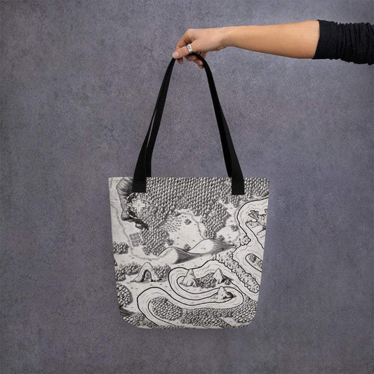 A model holds a tote bag featuring a black and white map by Deven Rue.