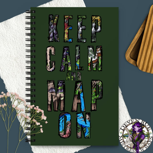 A green spiral notebook with "Keep Calm and Map On" written in bits of map.