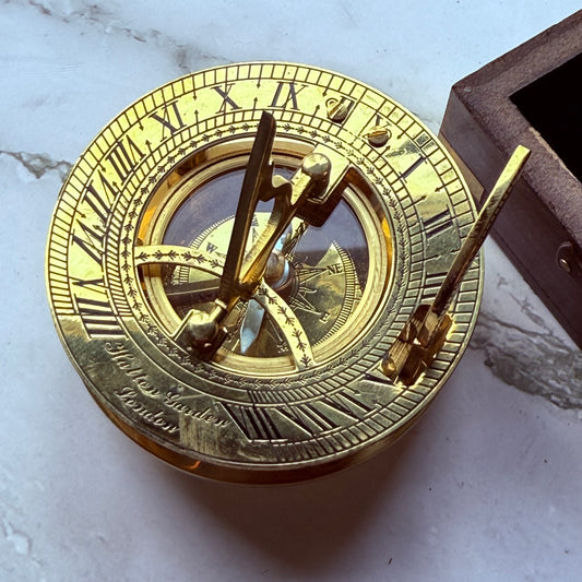 Brass sundial compass on a marble surface