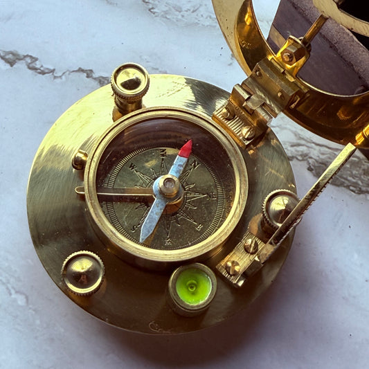 Brass compass with a white background