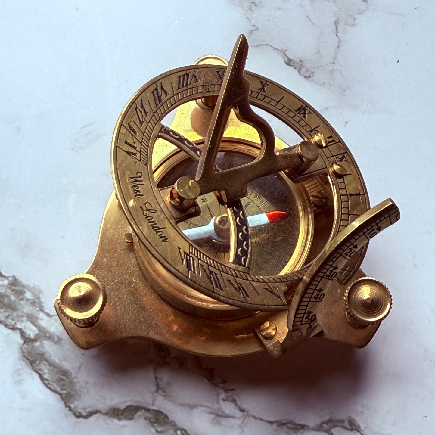 Vintage brass compass on a marble surface