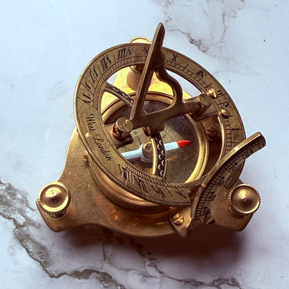 Vintage brass compass on a marble surface