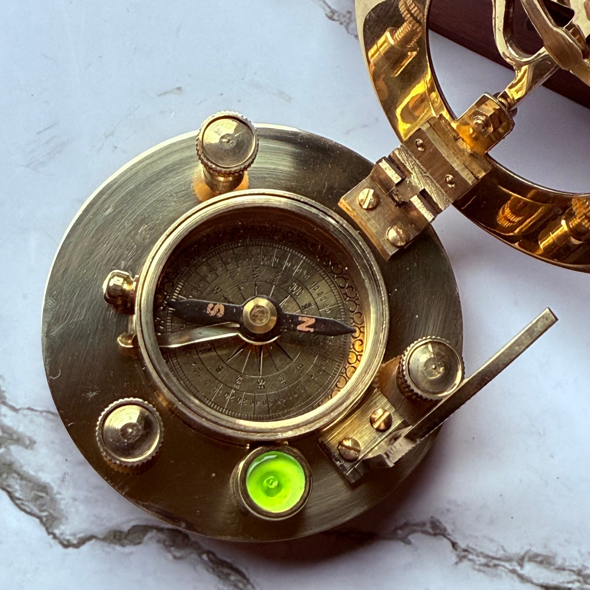 Brass compass on a marble surface