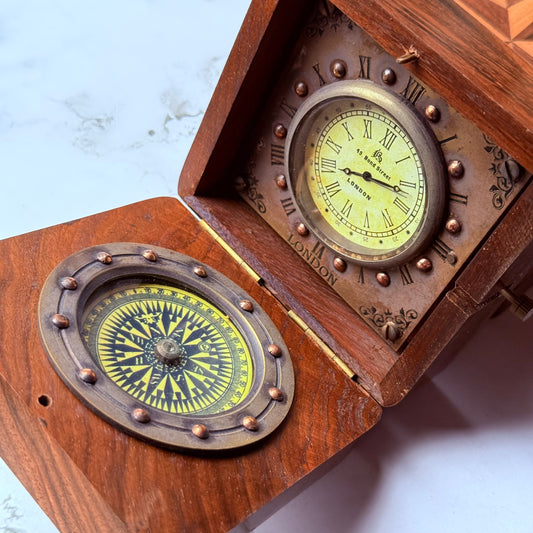 Wooden compass and clock set with brass accents on a light background