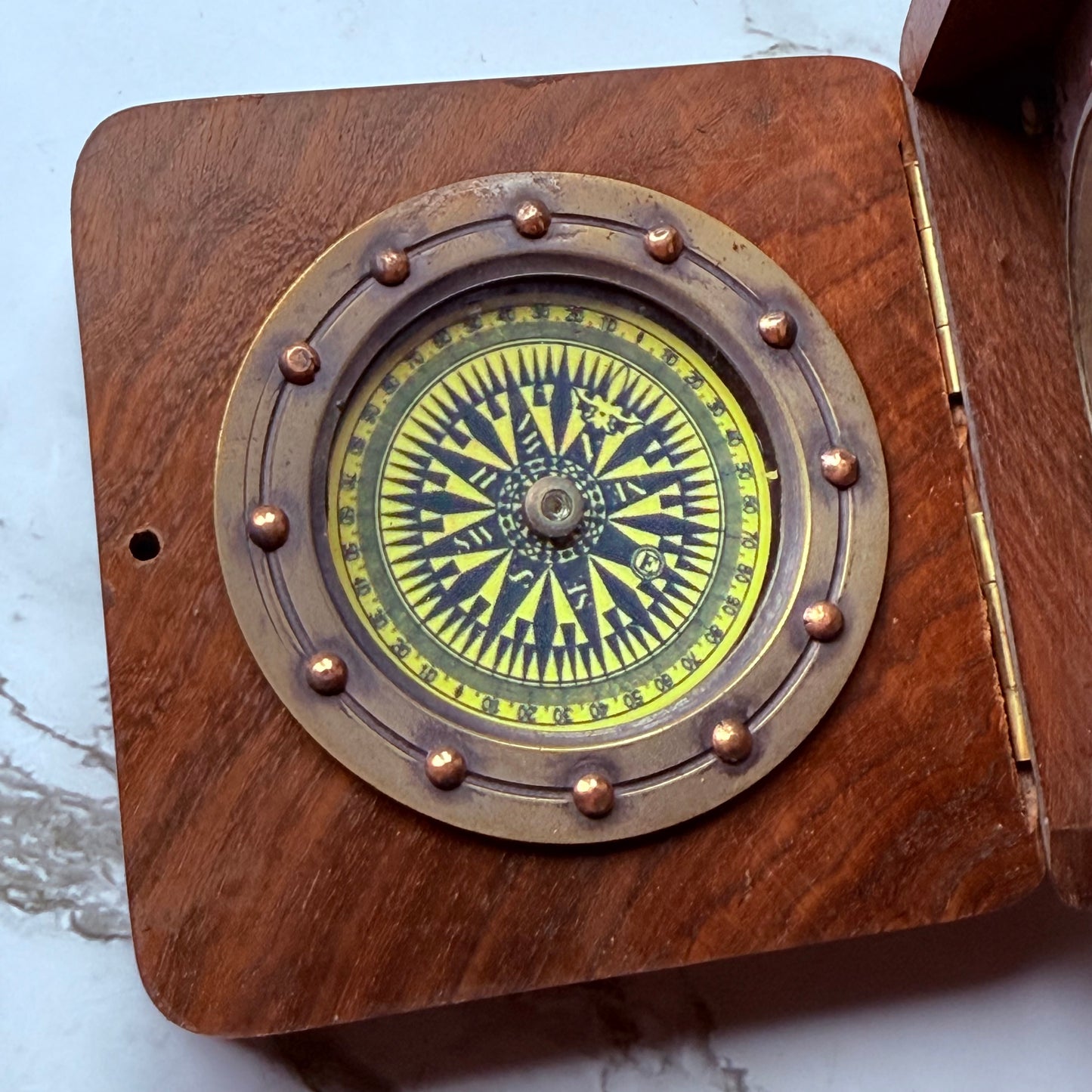 Wooden compass with brass accents on a white background