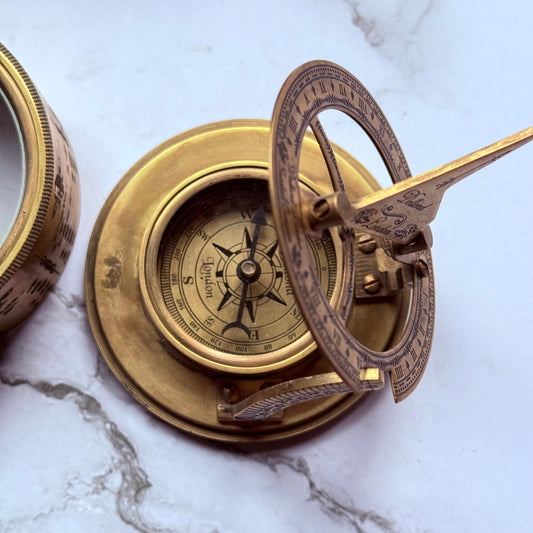 Brass compass on a marble surface