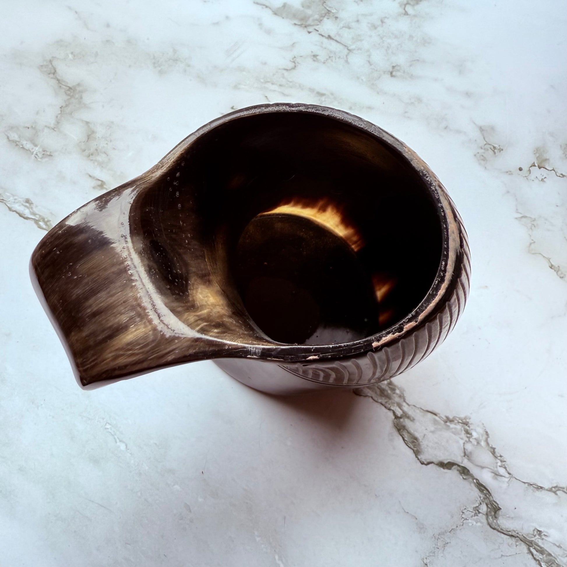 Horn-shaped mug with ribbed design and curved handle 