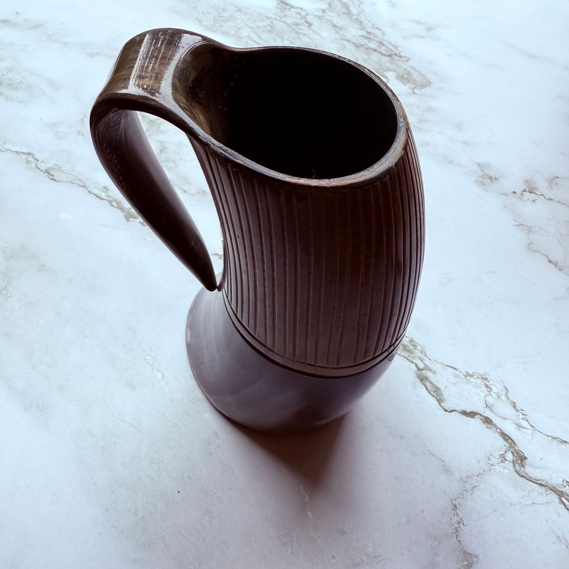 Horn-shaped mug with ribbed design and curved handle 