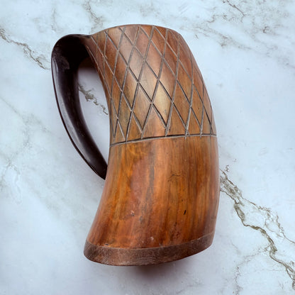 Horn-shaped mug with carved lattice design and curved handle 