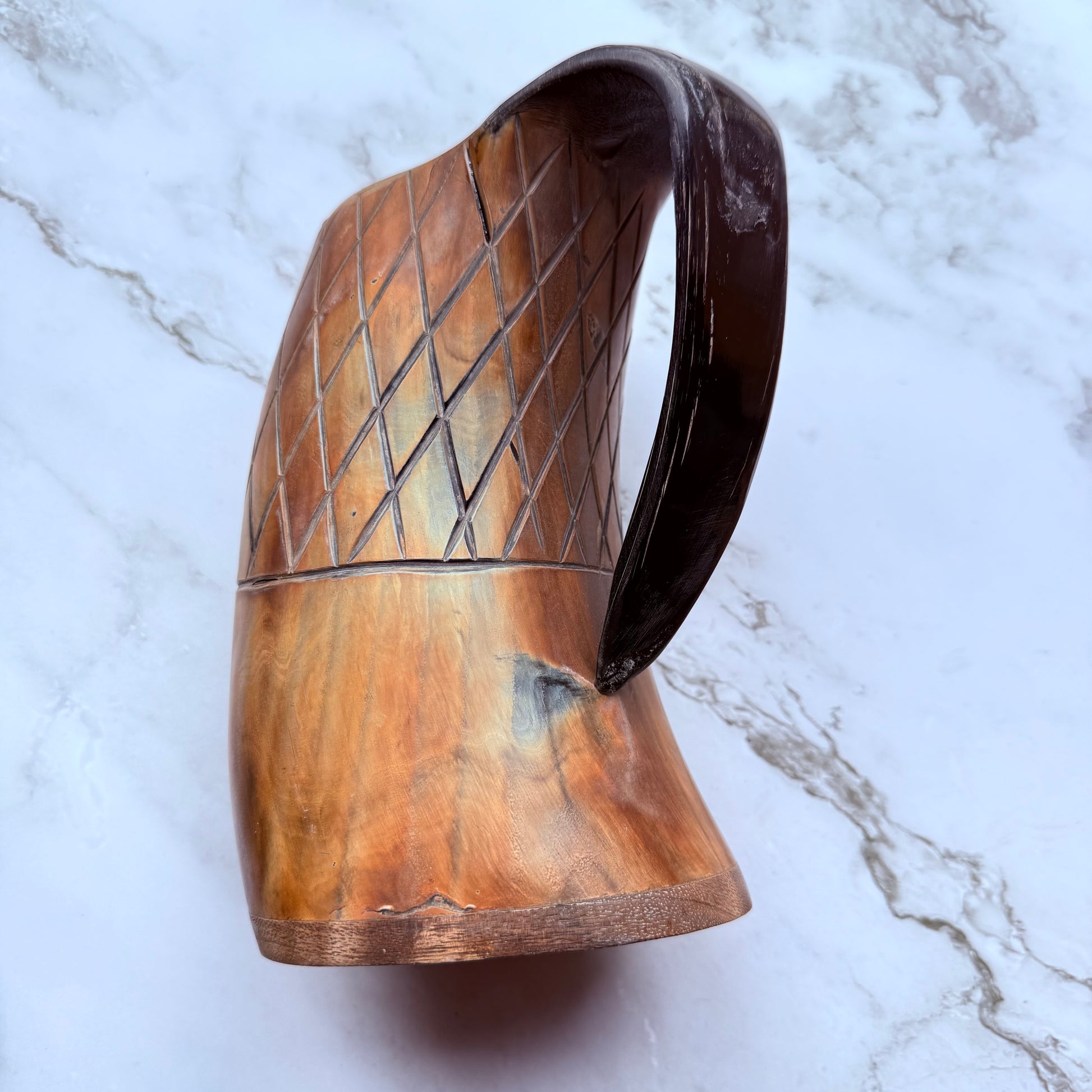 Horn-shaped mug with carved lattice design and curved handle 