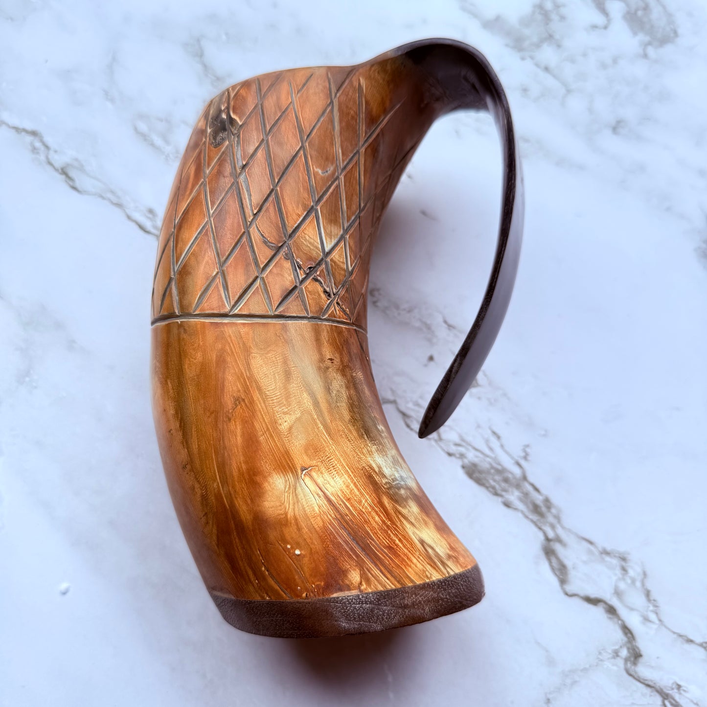 Horn-shaped mug with carved lattice design and curved handle 