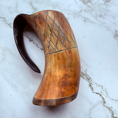 Horn-shaped mug with carved lattice design and curved handle 