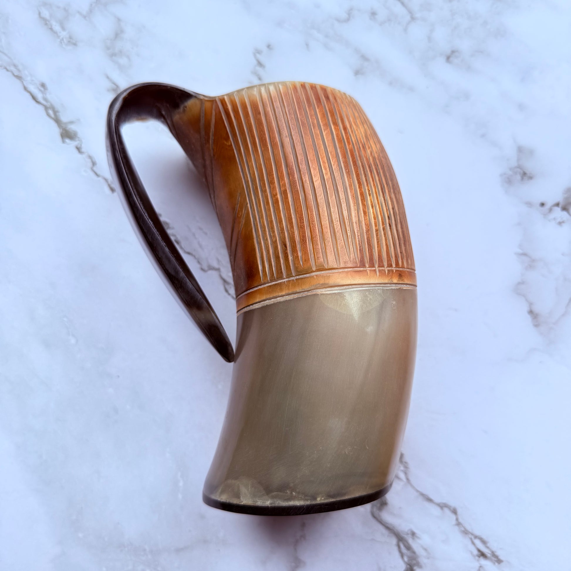 Horn-shaped mug with etched line design and curved handle 