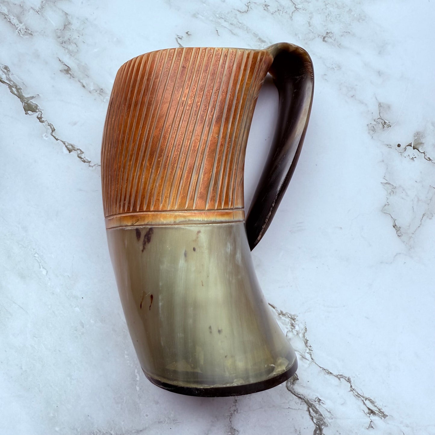 Horn-shaped mug with etched line design and curved handle 