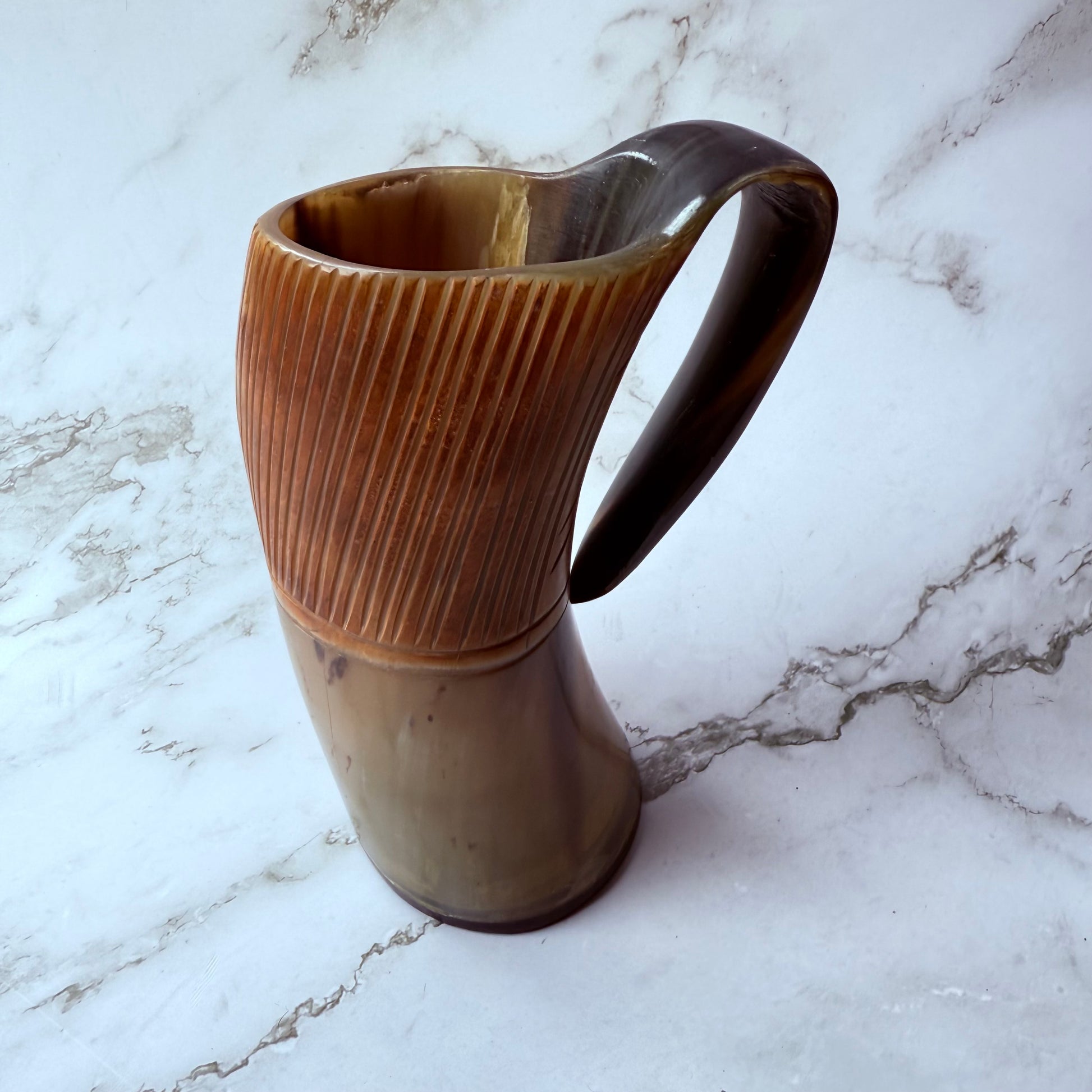 Horn-shaped mug with etched line design and curved handle 