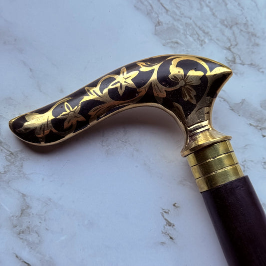 Decorative walking cane handle with brass floral patterns 