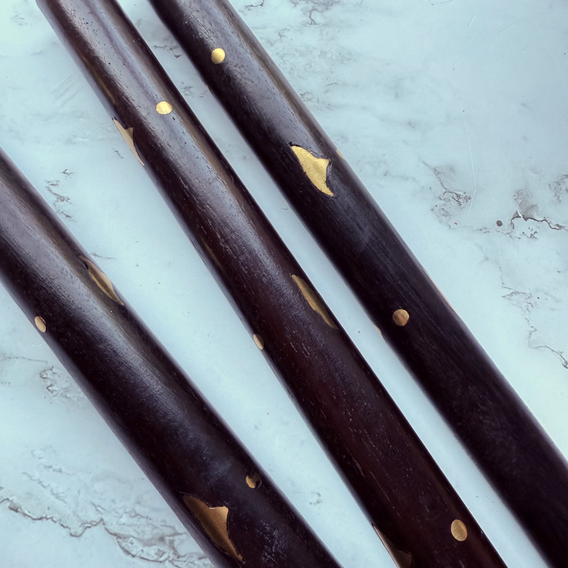 Close up of the wooden shaft of the cane with brass inlay design