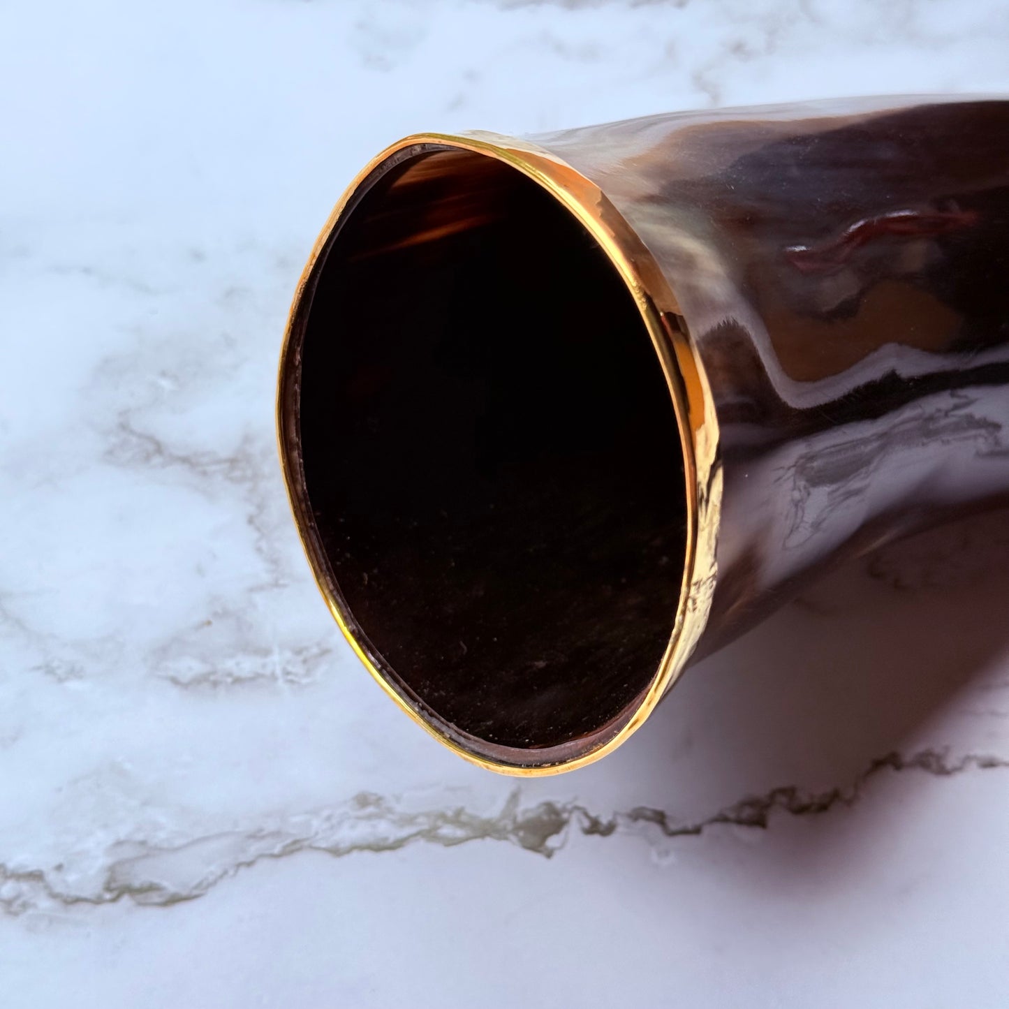 Closeup detail of the gold trimmed mouth of the drinking horn.