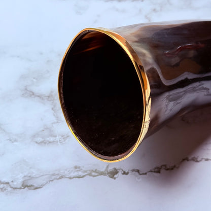 Closeup detail of the gold trimmed mouth of the drinking horn.