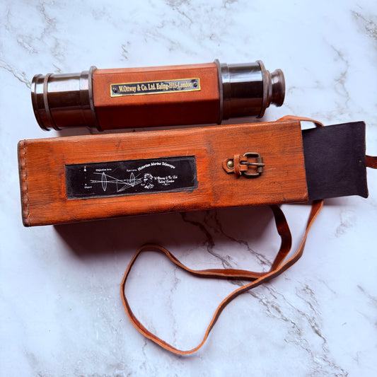 Vintage spyglass with leather case on a marble surface