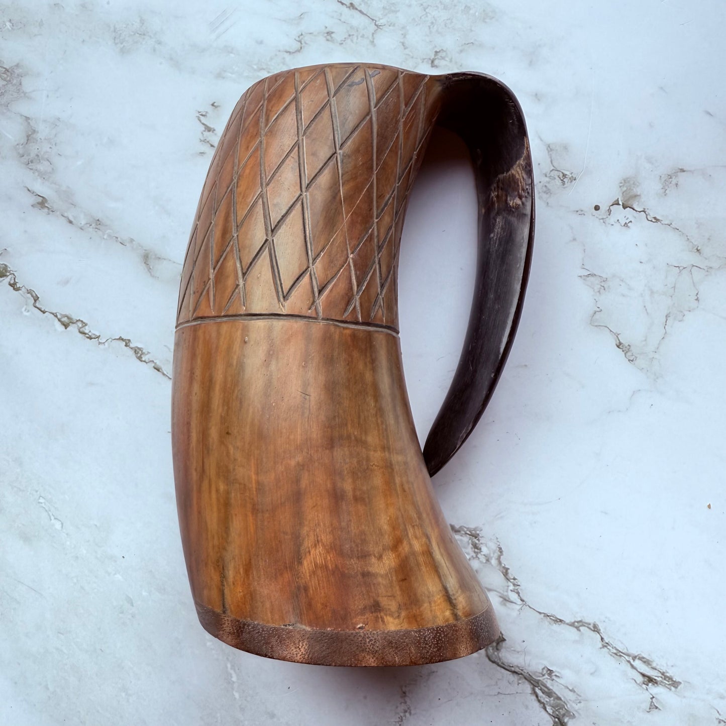 Horn-shaped mug with carved lattice design and curved handle 