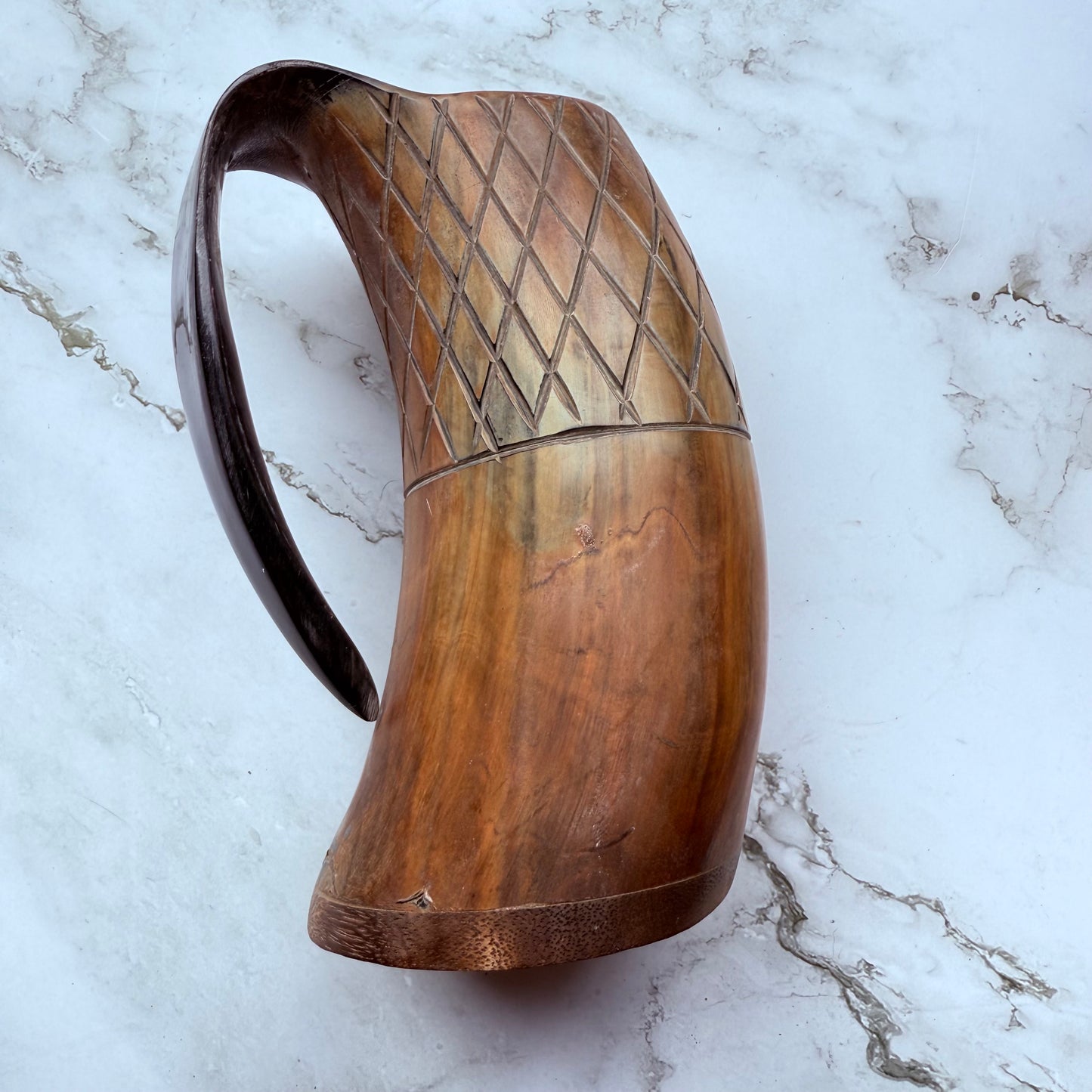 Horn-shaped mug with carved lattice design and curved handle 