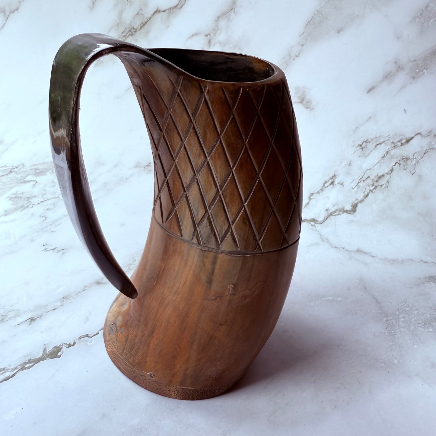 Horn-shaped mug with carved lattice design and curved handle 
