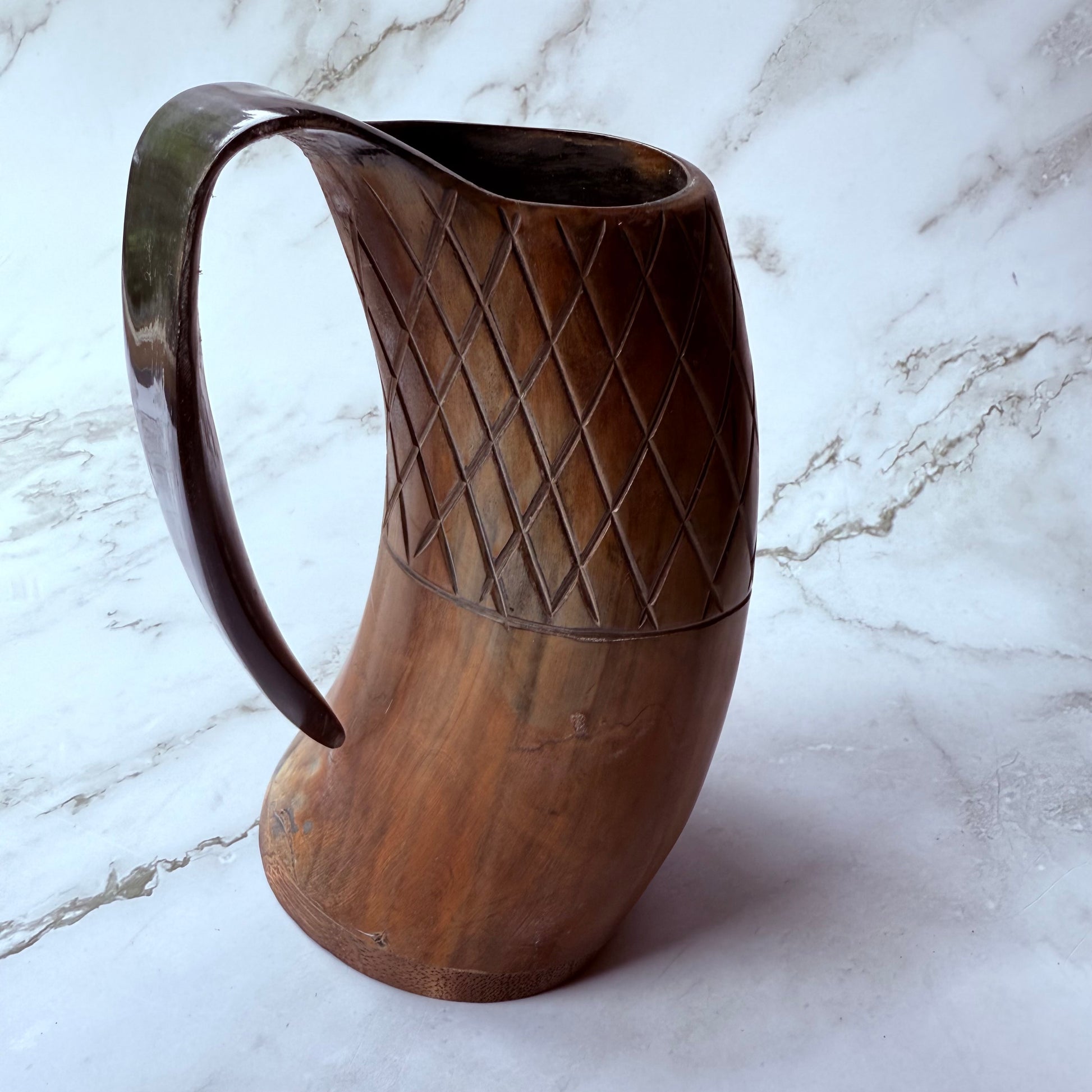 Horn-shaped mug with carved lattice design and curved handle 