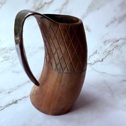 Horn-shaped mug with carved lattice design and curved handle 