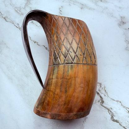 Horn-shaped mug with carved lattice design and curved handle 