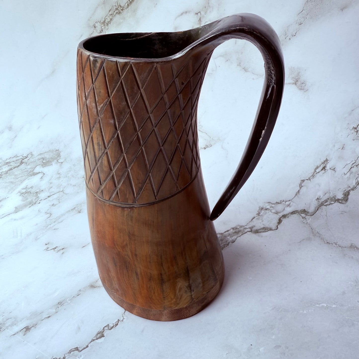 Horn-shaped mug with carved lattice design and curved handle 