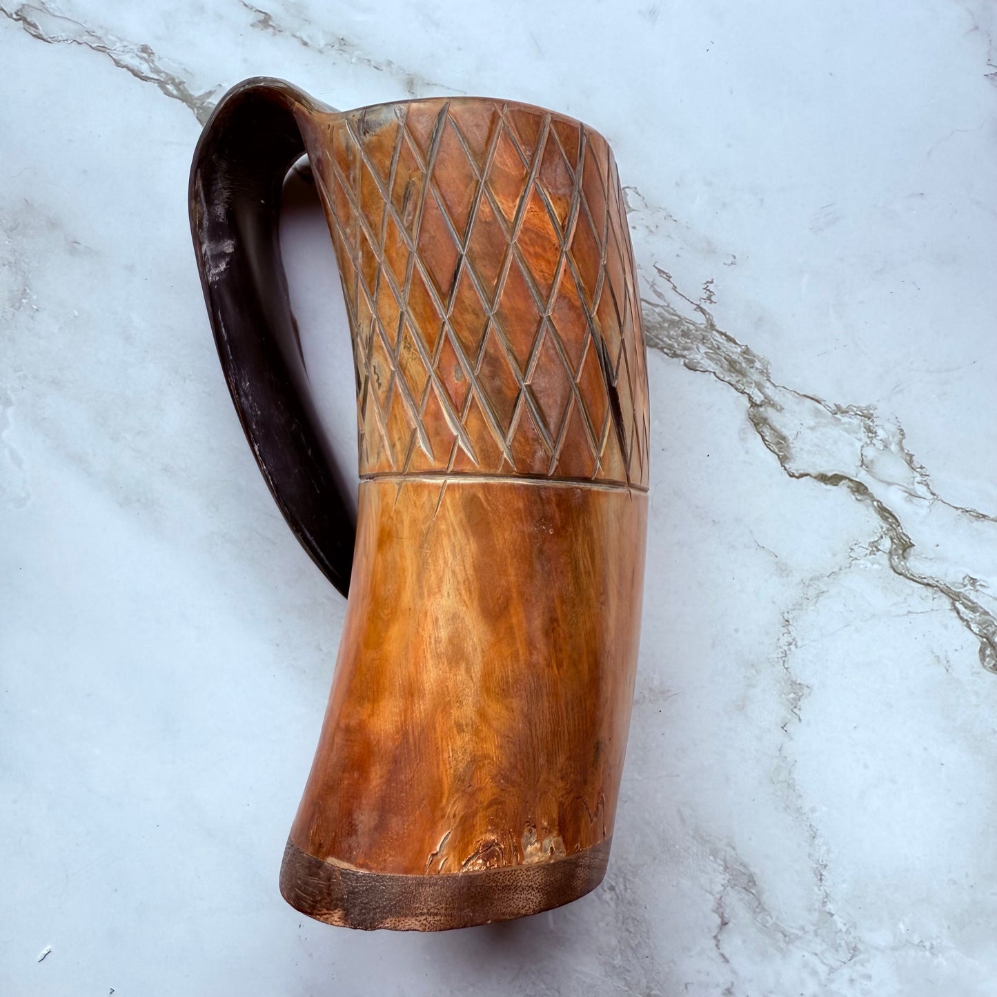 Horn-shaped mug with carved lattice design and curved handle 