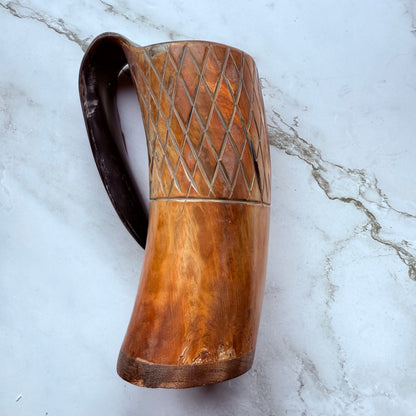 Horn-shaped mug with carved lattice design and curved handle 