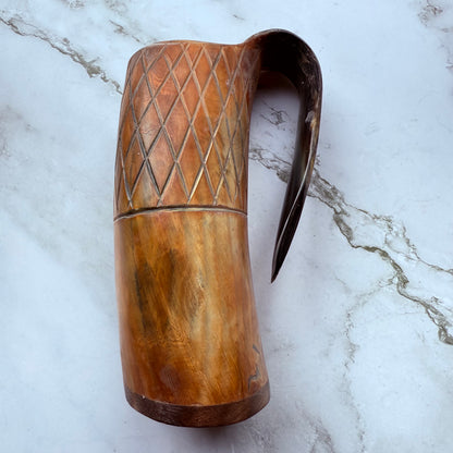 Horn-shaped mug with carved lattice design and curved handle 