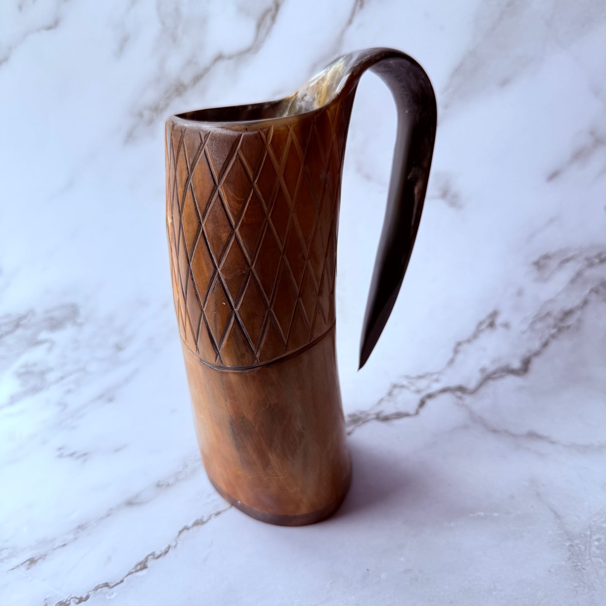 Horn-shaped mug with carved lattice design and curved handle 